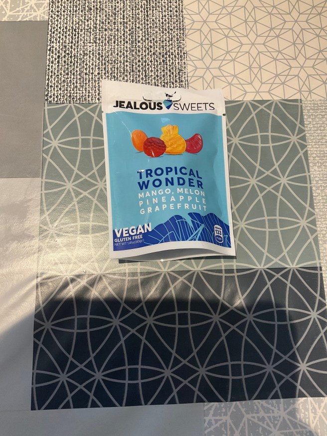 A packet of Jealous Sweets Tropical Wonder lies on a tablecloth with various duck egg colour scheme patterns.