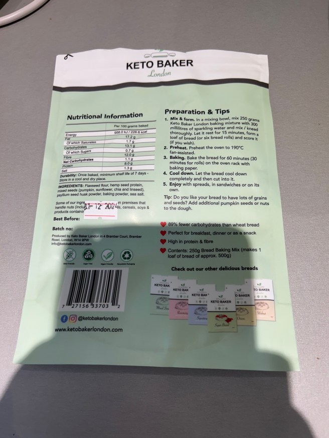 The back of the Keto Baker Mixed Seeds bread mix packet lies on a grey kitchen worktop.