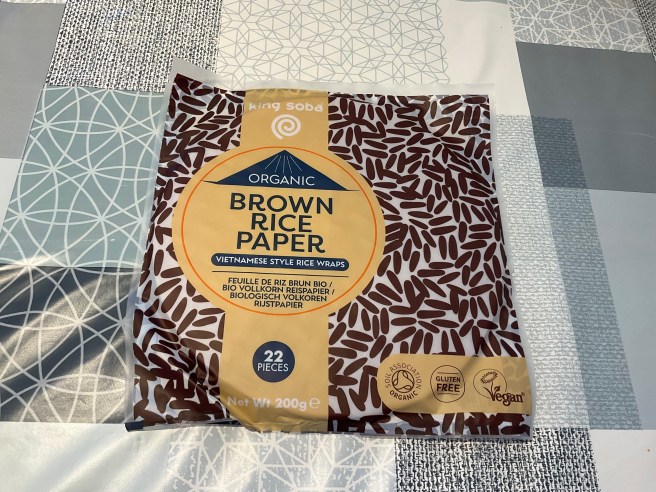 A packet of King Soba Brown Rice Paper Wraps lies on a tablecloth with duck egg colour scheme patterns.
