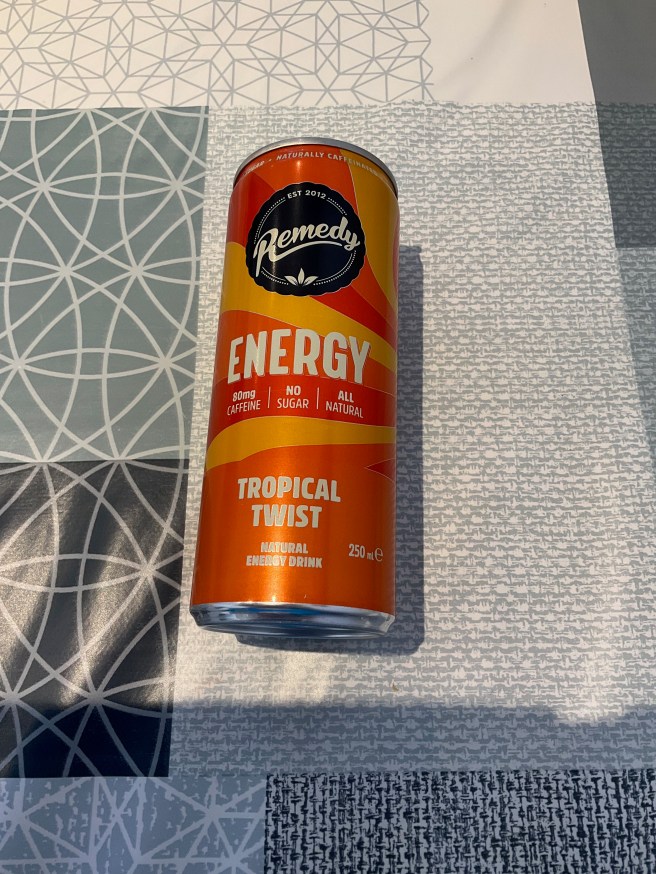 A can of Remedy Energy drink lies on a tablecloth with duck egg colour scheme patterns.